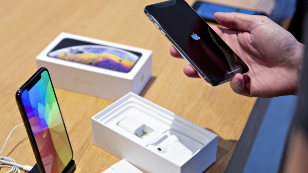 A customer view an Apple Inc. iPhone XS during a sales launch at a store in Chicago, Illinois, U.S., on Friday, Sept. 21, 2018. The iPhone XS is up to $200 more expensive than last years already pricey iPhone X and represents one of the smallest advances in the product lines history. But that means little to the Apple Inc. faithful or those seeking to upgrade their older iPhone. 