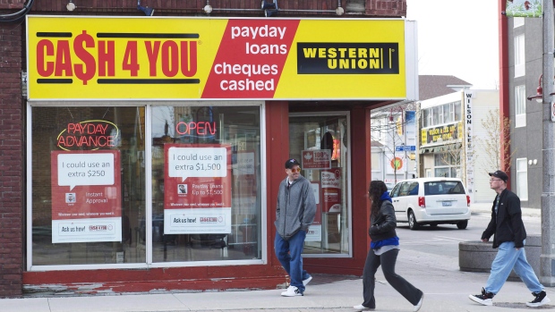 People walk pass a pay day loan store in Oshawa, Ont., on May 13, 2017.  
