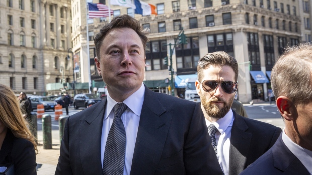 Elon Musk, chief executive officer of Tesla Inc., left, arrives at federal court in New York, U.S., on Thursday, April 4, 2019.