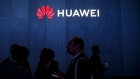 Attendees walk past signage displayed outside the Huawei Technologies Co. booth at the 2019 Consumer Electronics Show (CES) in Las Vegas, Nevada, U.S., on Wednesday, Jan. 9, 2019. Dozens of companies will give presentations at the event, where attendance is expected to top 180,000, with the trade war between the U.S. and China as well as Apple's sales woes looming over the gathering. 