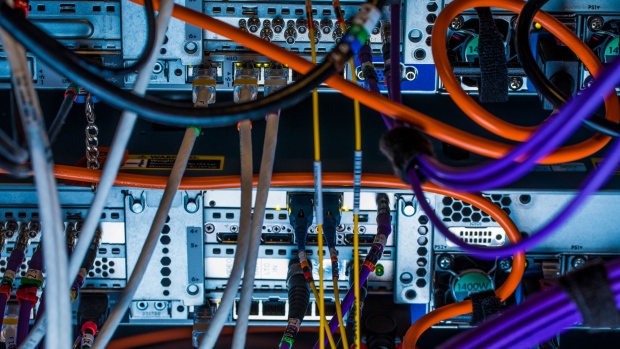 Cables feed into a serial digital interface (SDI) card inside a communications room at an office in London, U.K., on Monday, May 21, 2018. The Department of Culture, Media and Sport will work with the Home Office to publish a white paper later this year setting out legislation, according to a statement, which will also seek to force tech giants to reveal how they target abusive and illegal online material posted by users. 