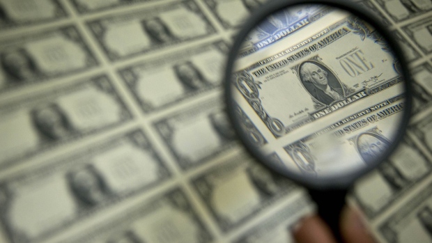 A magnifying glass is held over a 50 subject one dollar note sheet after being printed by an intaglio printing press in this arranged photograph at the U.S. Bureau of Engraving and Printing in Washington, D.C., U.S., on Tuesday, April 14, 2015. 