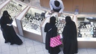 Female shoppers wearing traditional Saudi Arabian dress browse watches on sale at a luxury concession stand inside the Kingdom Centre shopping mall in Riyadh, Saudi Arabia. 