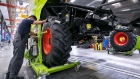 An employee fits wheels to a Lexion 770 combine harvester on the production line at the Claas KGaA factory in Harsewinkel, Germany, on Monday, Aug. 28, 2017. Claas Group, a 104-year-old, family-owned manufacturer of harvesters, threshers and tractors, is hunting for revenue by outfitting machines with sensors, cameras and software to help its products stand out amid slumping demand. 