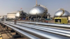 Three-phase spheroids stand behind pipelines at Saudi Aramco's crude oil processing facility