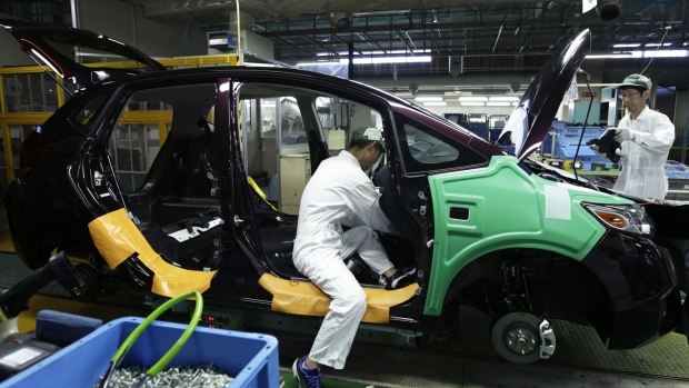 Workers assemble a Honda Motor Co. North America-bound Fit vehicle on the production line at the company's Suzuka factory in Suzuka, Mie, Japan, on Tuesday, Aug. 23, 2016. Attracting the best information technologists is becoming increasingly important for Honda Motor Co. and other carmakers as they seek a bigger share of revenue from IT-driven services such as ride-sharing and cloud-based monitoring of vehicles. 