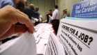 Job seekers look over job opening fliers at the WorkSource exhibitat the Pasadena Convention Center 