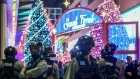 Riot police stand guard near an entrance to Harbour City shopping mall, operated by Wharf Holdings Ltd., at night in Tsim Sha Tsui district of Hong Kong, China, on Sunday, Dec. 15, 2019. Rents in Hong Kong's prime shopping districts will fall sharply in 2020, as the city's retail sales experience the worst contraction ever amid lingering anti-government protests, according to Knight Frank LLP. 