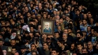 Protesters hold up an image of Qassem Soleimani