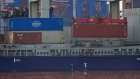 A crane lowers shipping containers onto cargo vessel 'Sondeborg', operated by Carsten Rehder Schiffsmakler Und Reederei GmbH, at the port of Hamburg in Hamburg, Germany, on Tuesday, March 3, 2020. As the coronavirus wreaks havoc on physical supply chains and global trade, the shipping industry is rife with canceled voyages, idle containers and falling rates. Photographer: Krisztian Bocsi/Bloomberg