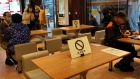 Social distancing signs are seen on tables at a restaurant in Hong Kong, Monday, March 30, 2020. 