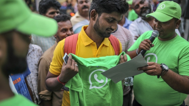 Jio Does It Again As New Deal Sends Shares Tumbling talpeggif a-spectator-holds-a-branded-t-shirt-during-a-roadshow-for-facebook-inc-s-whatsapp-messaging-service-and-reliance-jio-infocomm-ltd-s-wireless-network-in-pune-india-on-thursday-oct-25-2018-facebook-and-reliance-jio-are-teaming-up-to-draw-hordes-of-customers-with-cheap-phones-rock-bottom-rates-and-handy-messaging-services-photographer-dhiraj-singh-bloomberg