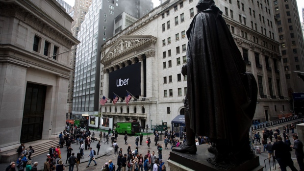 Pedestrians pass in front of the New York Stock Exchange (NYSE) during Uber Inc.'s initial public offering (IPO) in New York, U.S., on Friday, May 10, 2019. The No. 1 ride-hailing company's shares will start trading on the New York Stock Exchange after it raised $8.1 billion in the biggest U.S. IPO since 2014, pricing shares at $45 each. Photographer: Michael Nagle/Bloomberg