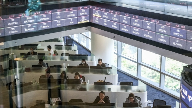 An electronic ticker is reflected on a window at the Philippine Stock Exchange in Bonifacio Global City (BGC) Metro Manila, the Philippines, on Friday, March 13, 2020. A month long lockdown in the Philippine capital to contain the spread of coronavirus is set to curb economic growth and make an interest-rate cut next week more likely. Photographer: Veejay Villafranca/Bloomberg