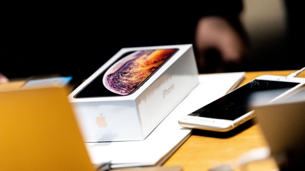 An Apple Inc. iPhone XS smartphone box sits on a shopping bag during a sales launch at a store in New York, U.S., on Friday, Sep. 21, 2018. The iPhone XS is up to $200 more expensive than last year's already pricey iPhone X and represents one of the smallest advances in the product line's history. But that means little to the Apple Inc. faithful or those seeking to upgrade their older iPhone. Photographer: Jeenah Moon/Bloomberg