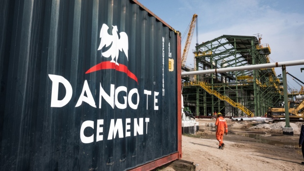 A Dangote Cement Plc logo stands on a barrier at the under-construction Dangote Industries Ltd. oil refinery and fertilizer plant site in the Ibeju Lekki district, outside of Lagos, Nigeria, on Thursday, July 5, 2018. The $10 billion refinery, set to be one of the world’s largest and process 650,000 barrels of crude a day, should be near full capacity by mid-2020, Devakumar Edwin, group executive director at Dangote Industries said in an interview. Photographer: Tom Saater/Bloomberg