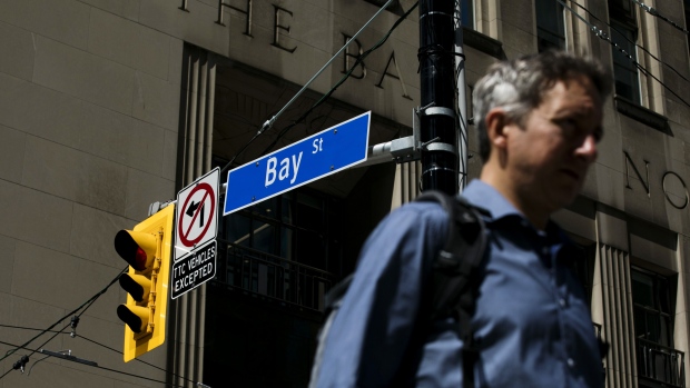 A pedestrian passes in front of a Bay Street sign in the financial district of Toronto, Ontario, Canada, on Thursday, July 25, 2019. Canadian stocks fell as tech heavyweight Shopify Inc. weighed on the benchmark and investors continued to flee pot companies. Photographer: Brent Lewin/Bloomberg