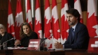 Chrystia Freeland speaks alongside Justin Trudeau at an Ottawa news conference on Oct. 9.