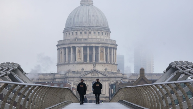 City of London police officers walk across the Millennium Bridge in view of St. Paul's Cathedral in London, U.K., on Thursday, Nov. 5, 2020. The Bank of England boosted its bond-buying program by a bigger-than-expected 150 billion pounds ($195 billion) in another round of stimulus to help the economy through a second wave of coronavirus restrictions. Photographer: Simon Dawson/Bloomberg
