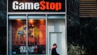 A pedestrian wearing a protective mask walks past a a GameStop Corp. store in the Herald Square area of New York, U.S., on Friday, Nov. 27, 2020. With sparse crowds and none of the stampedes of holidays past, some retail watchers started to refer to Black Friday as Blase Friday instead -- and that was even before the virus hit.