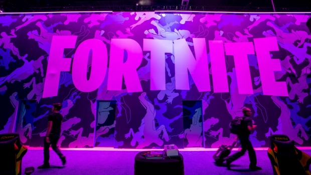 Attendees walk past signage for Epic Games Inc. Fortnite video game during the E3 Electronic Entertainment Expo in Los Angeles, California, U.S., on Wednesday, June 12, 2019. For three days, leading-edge companies, groundbreaking new technologies and never-before-seen products are showcased at E3. Photographer: Kyle Grillot/Bloomberg