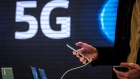 A customer browses a smartphone device in front of a 5G logo inside the Movistar center, operated by Telefonica SA, in Barcelona, Spain, on Thursday, Jan. 21, 2021. Telefonicas sale of telecommunication masts to American Tower Corp. opens a new front in the race to control Europes fast-growing tower industry.