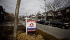 A "For Sale" sign sits in front of a home in Toronto on March 11, 2021.