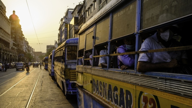Passengers sit in buses as MG Road in Kolkata, India, on Wednesday, April 28, 2021. As West Bengal heads to the polls tomorrow, for the eighth and final phase of the state's election, Indian Prime Minister Narendra Modi faces growing criticism across the political spectrum for holding large election rallies as the countrys health system reels from a deadly wave of Covid-19 cases, forcing citizens to beg for oxygen and hospital beds on Twitter. Photographer: Arko Datto/Bloomberg