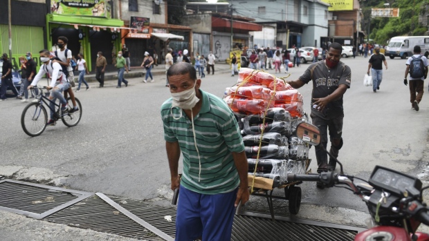 Workers wearing protective masks pull a cart in the Petare neighborhood of Caracas, Venezuela, on Thursday, Sept. 3, 2020. After a dip in late August, Venezuela is seeing an uptick of daily cases as the country nears 50,000 infections. Photographer: Carlos Becerra/Bloomberg