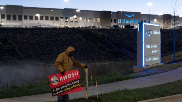 BESSEMER, AL - MARCH 29: An RWDSU union rep holds a sign outside the Amazon fulfillment warehouse at the center of a unionization drive on March 29, 2021 in Bessemer, Alabama. Employees at the fulfillment center are currently voting on whether to form a union, a decision that could have national repercussions. (Photo by Elijah Nouvelage/Getty Images) Photographer: Elijah Nouvelage/Getty Images North America