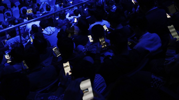                             Members of the audience use their smartphones during an unveiling event for Xiaomi Corp.'s Mi MIX 2S smartphone in Shangha