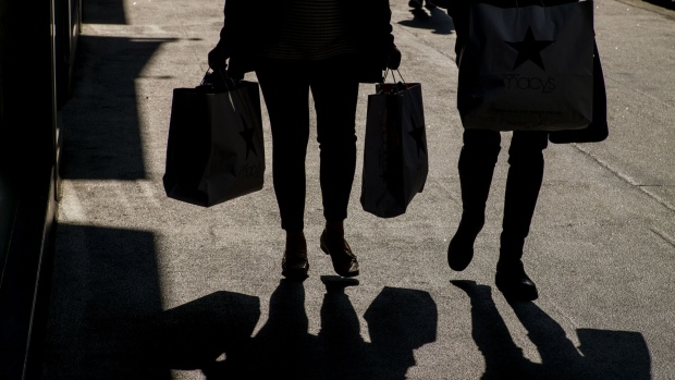 The silhouettes of pedestrians carrying shopping bags.