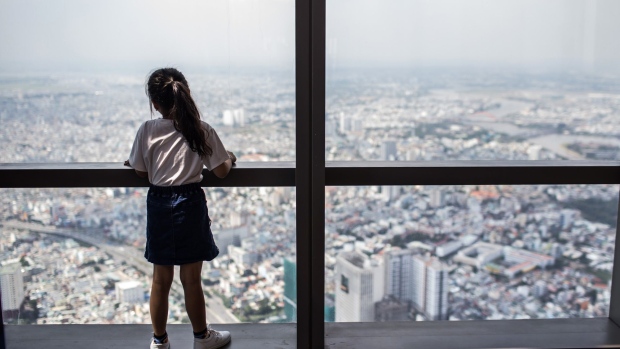 A girl looks out at a view of the skyline from the Skyview observation deck in the Vinpearl Luxury Landmark 81 hotel, developed by Vinhomes JSC, in Ho Chi Minh City, Vietnam, on Monday, Oct. 14, 2019. The Vingroup umbrella covers dozens of businesses that touch Vietnamese from childhood through senescence. Vingroup units have a combined market value of about $28 billion, or about 16% of the total value of the Vietnam's publicly traded companies. Photographer: Yen Duong/Bloomberg