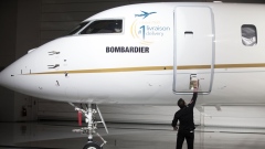 An employee opens the door on a Bombardier jet in Montreal, Quebec.