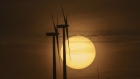 The sun rises beyond the Muras II wind farm in Muras, Spain.
