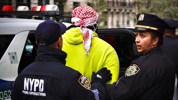 NYPD officers detain a person as pro-Palestinian protesters gather outside of Columbia University in New York City on April 18. Photographer: Kena Betancur/AFP/Getty Images