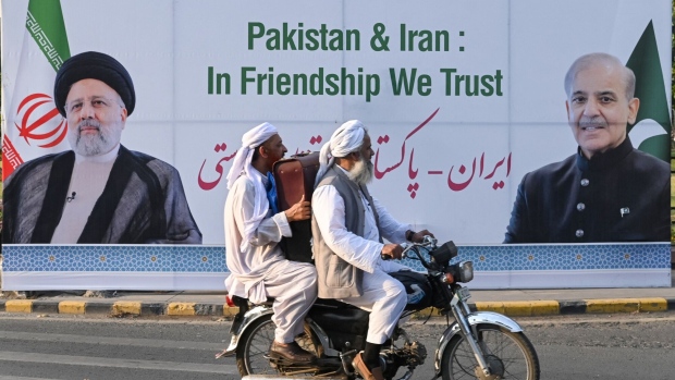 Commuters ride past a welcoming billboard showing Ebrahim Raisi and Shehbaz Sharif in Lahore, Pakistan on April 22. Photographer: Arif Ali/AFP/Getty Images