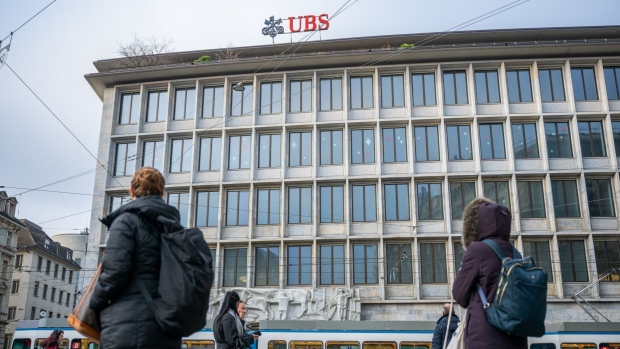 Commuters pass a UBS Group AG bank branch in Zurich, Switzerland. Photographer: Pascal Mora/Bloomberg