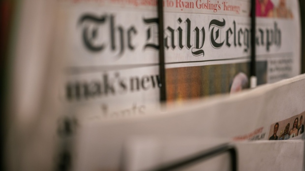 Copies of The Daily Telegraph newspaper for sale on a newsstand in London.