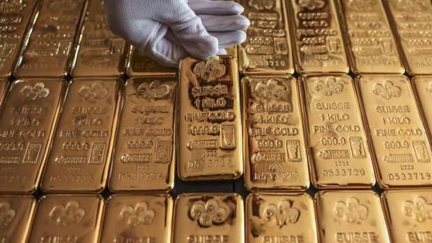 An employee handles one kilogram gold bullions at the YLG Bullion International Co. headquarters in Bangkok, Thailand.