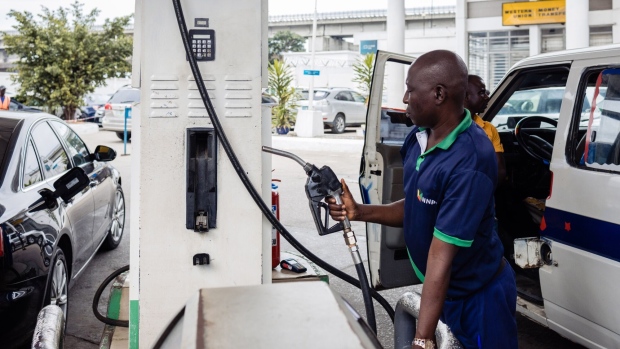 <p>An attendant handles a fuel pump at a gas station in Lagos, Nigeria.</p>