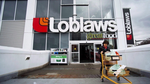 A woman carts out her groceries from a Loblaws grocery store in Toronto on May 1, 2014.