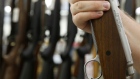 A person holds a Remington Outdoor Co. Model 700 rifle for sale at a gun store in Orem, Utah