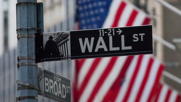 A Wall Street street sign hangs in front of the New York Stock Exchange (NYSE) in New York, U.S., on Friday, April 13, 2018.