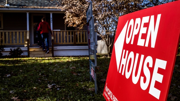 An "Open House" sign is displayed as potential home buyers arrive at a property for sale in Columbus, Ohio, U.S., on Sunday, Dec. 3, 2017.