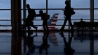 Travelers walk past an American Airlines Group Inc. aircraft at Ronald Reagan National Airport (DCA) in Washington, D.C.