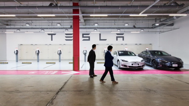 Customers look at a Tesla Motors Inc. Model S 90D electric vehicles parked at the company's charging station in the Starfield Hanam shopping complex, operated by Shinsegae Co., in Hanam, Gyeonggi Province, South Korea, on Wednesday, March 15, 2017. Tesla produced almost 84,000 vehicles in 2016 and plans to make half a million in 2018, then 1 million in 2020.