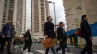 Commuters pass faded banners depicting Iran's religious leaders while crossing a street in Tehran.