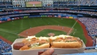 A spectator holds up a hot dog at a Blue Jays game in Toronto