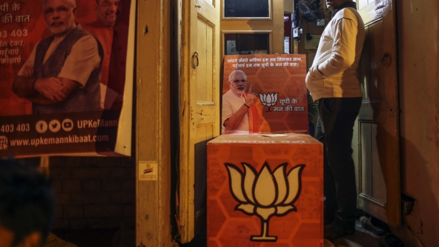 Bharatiya Janata Party (BJP) advertisments featuring images of Narendra Modi, India's prime minister, sits outside a store at Godowlia Market in Varanasi, Uttar Pradesh, India, on Thursday, Dec. 8, 2016. Modi's Nov. 8 decision to ban high-value currency notes, effectively cancelling 86 percent of cash in circulation, was designed to stifle corruption and tax evasion, but many of the hardest-hit are workers in India's vast and intricate informal economy -- the small businesses, shops, weavers and countless other basic industries and services that employ more than 90 percent of Indian workers. 